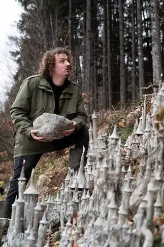 Image du chien du sculpteur suisse François Monthoux devant sa sculpture.