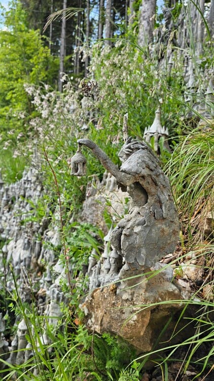 Image du sculpteur suisse François Monthoux devant sa sculpture.